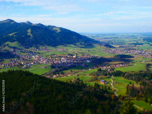 Tilt shift image of village in green mountain landscape