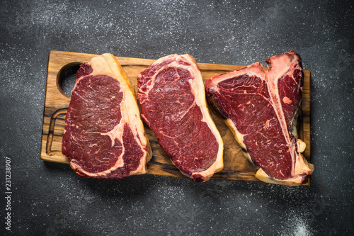 Raw meat beef steak on black top view.