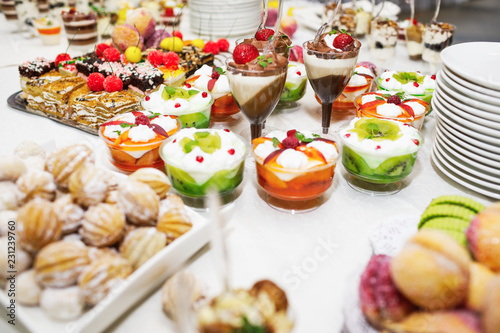 Modern desserts, cupcakes, sweets with fruits. Delicious candy bar. Catering Concept.