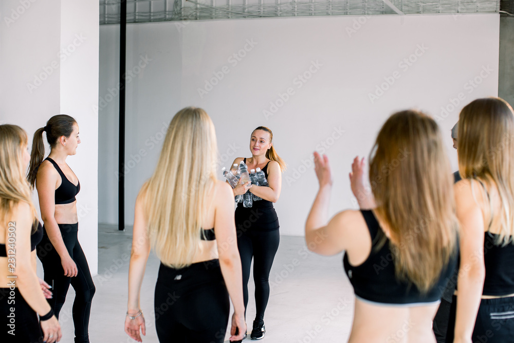 Naklejka premium A group of young girls in the fitness room are waiting for them to bring water