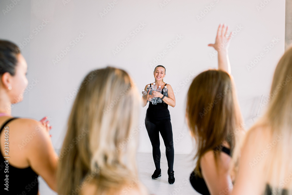 Naklejka premium A group of young girls in the fitness room are waiting for them to bring water