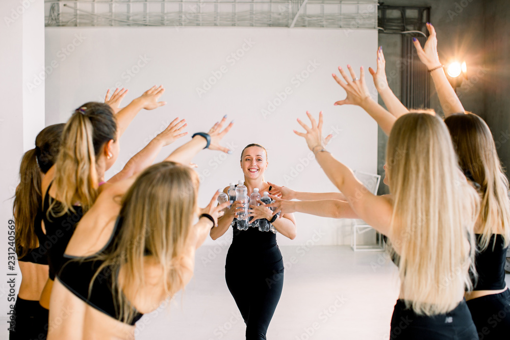 Fototapeta premium A beautiful young girl carries water for her friends after yoga lessons