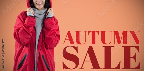 Composite image of smiling woman in hooded jacket standing photo