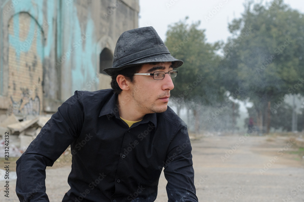 Hombre con sombrero, gafas y camisa negra fumando 02