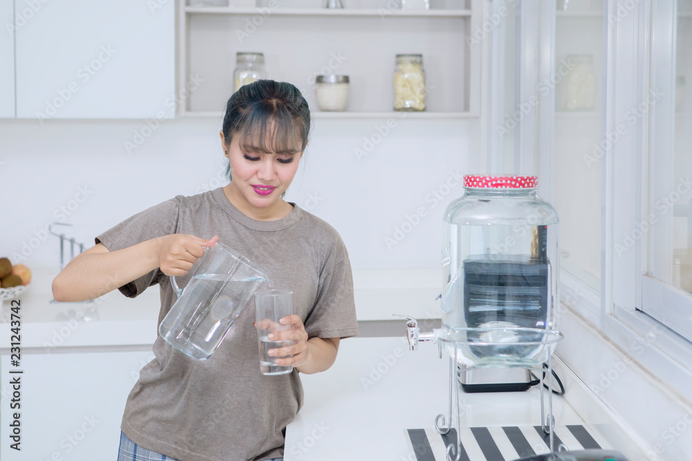 Pretty girl pouring fresh water at home Pretty girl pouring fresh water at home