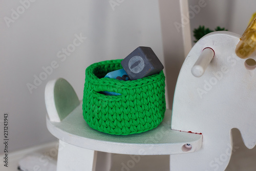Knitted basket for small things and toys in the interior of the children's room