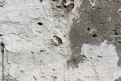 Deteriorating white and grey plastered wall texture background fragment photo