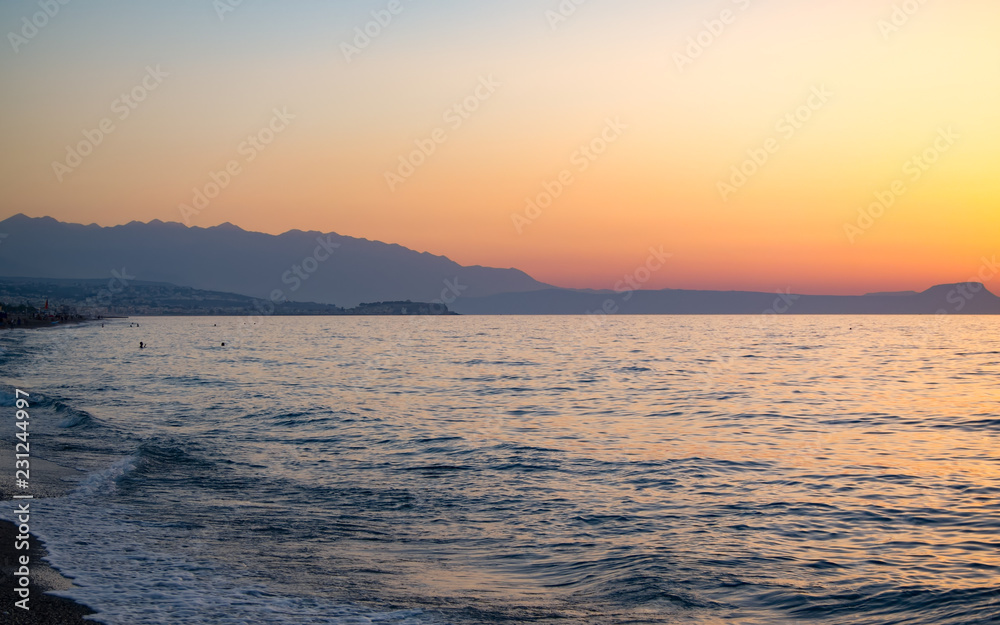 Sunset in the beach of Aegeian sea in Adelianos Kampos resort, Crete island, Greece