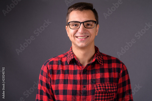 Studio shot of young handsome man against gray background © Ranta Images
