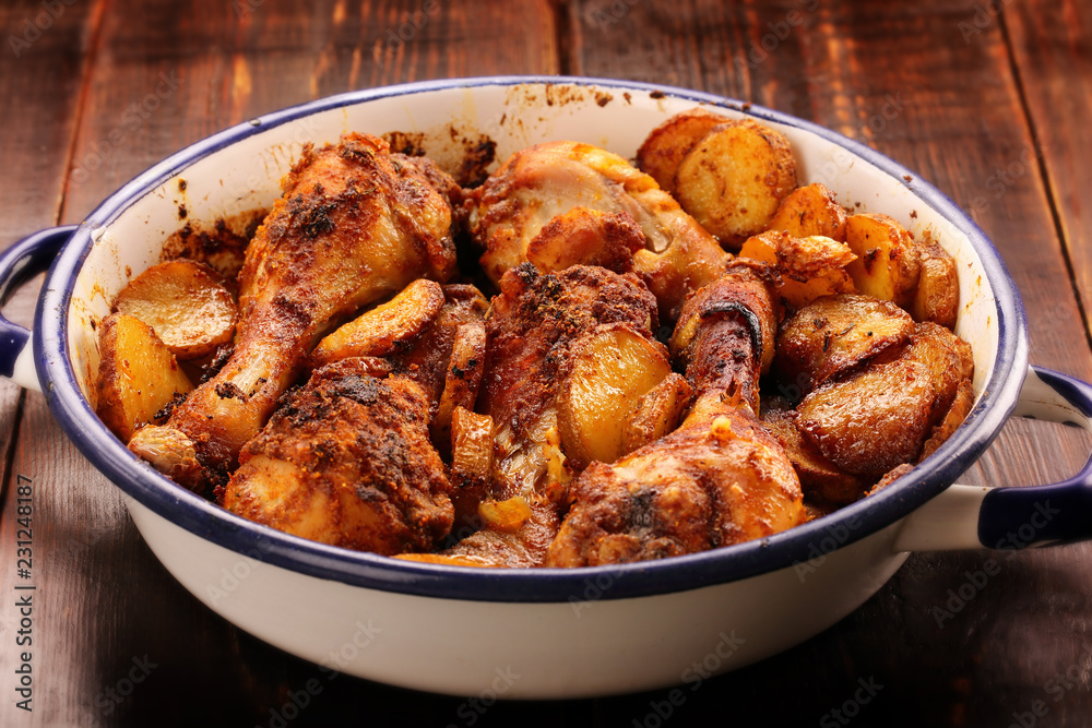 Roasted chicken drumstick with potatoes and salad on wooden background Roasted chicken drumstick with potatoes and salad on wooden background