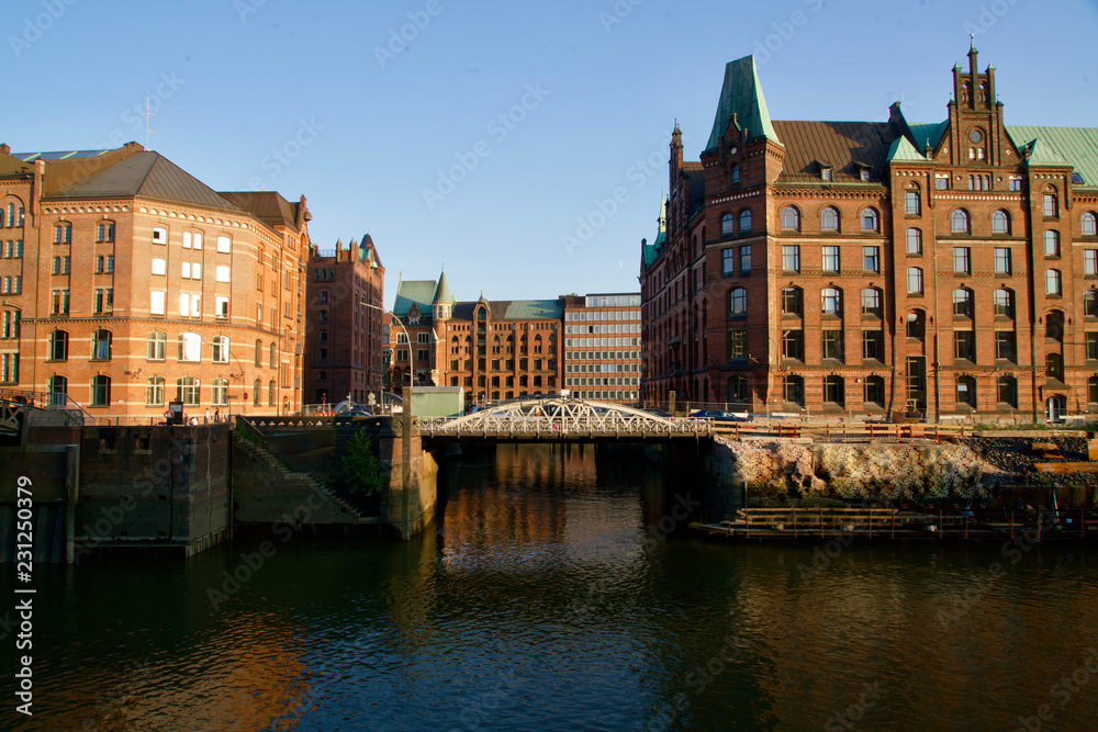 Red houses of the Speicherstadt mirroring in the water