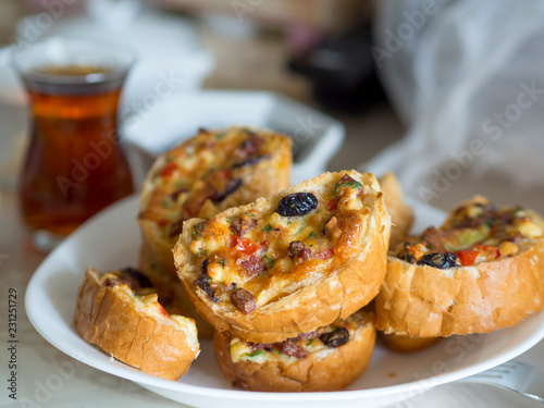 fried breakfast bread slices in the oven and egg, cheese, olives, tomato and sausage pieces © oktay