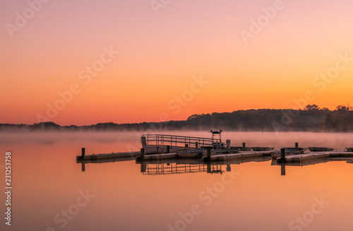 Peaceful lake view in Manasquan reservoir, New Jersey featuring mist on the background and beautiful sunrise colors