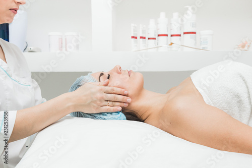 Young beautiful girl getting a facial massage in a beauty salon