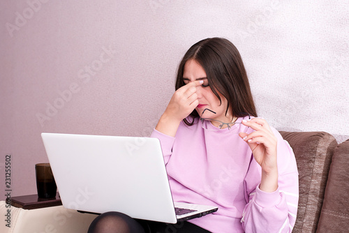 A woman working at the computer for a long time tired eyes