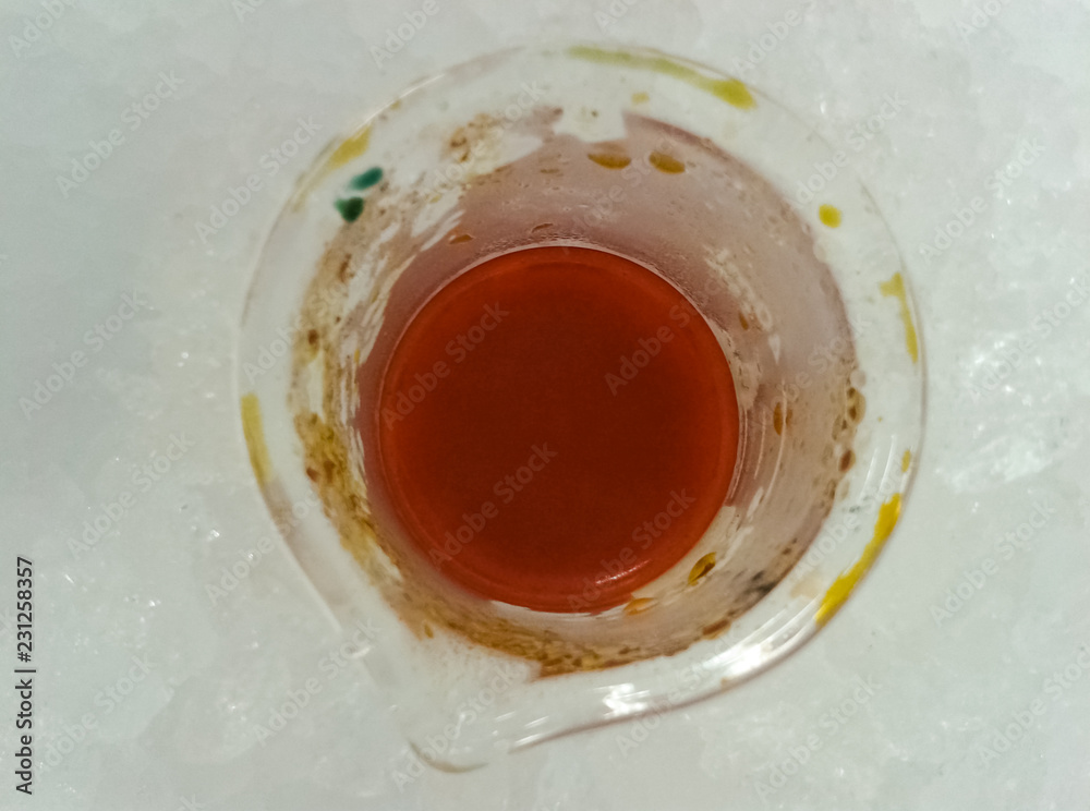Synthesis of an orange chemical inside a glass beaker cooling in an ice bath Synthesis of an orange chemical inside a glass beaker cooling in an ice bath
