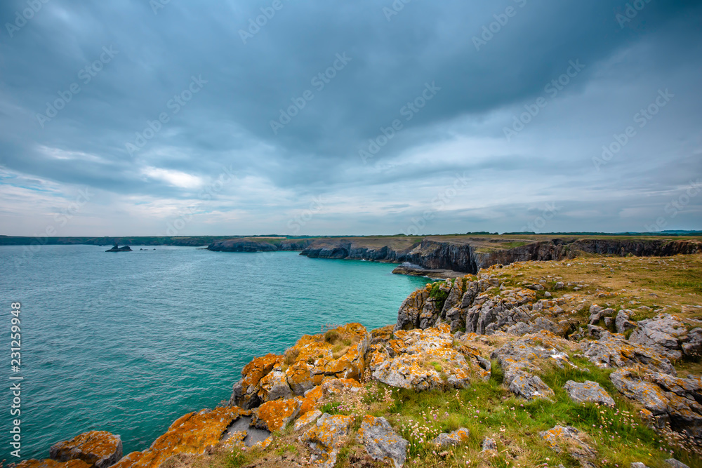 Dramatic rocky coastline of Pembrokeshire,United Kingdom on cloudy summer day.Scenic landscape without people.