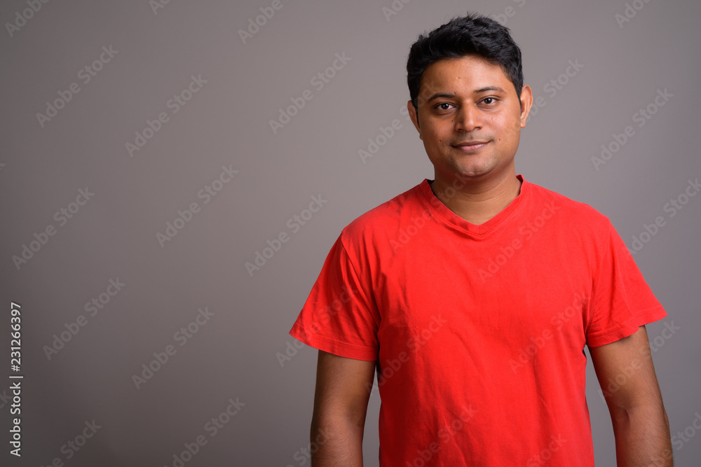 Obraz premium Portrait of young Indian man against gray background