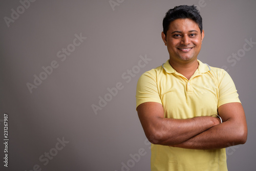 Portrait of young Indian man against gray background