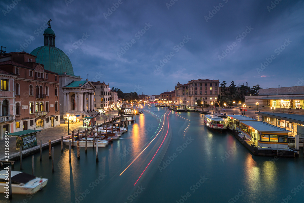 Night view on Grand Canal with passing by boat in Venice,long exposure photo.