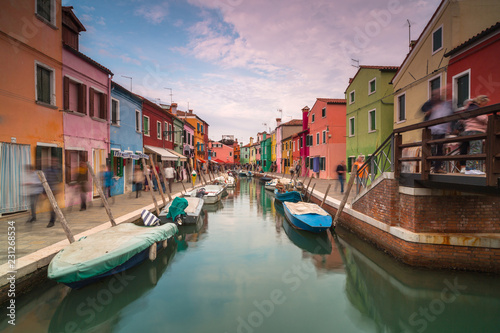 View on Rio Di San Mauro in Burano with passing people at sunset,long exposure photo. © Andriy Stefanyshyn