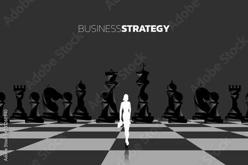 Silhouette of businesswomen with briefcase standing in front of chess piece. concept of business strategy marketing.