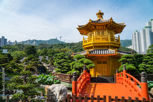 Beautiful golden pagoda in a peaceful garden surrounded by trees with a blue sky in the city