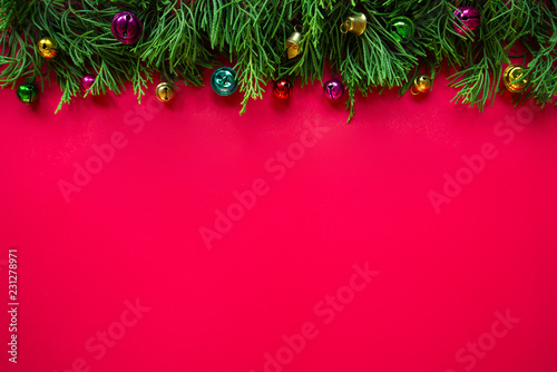 Christmas on the red background   Pine trees and ornaments on top  Copy space.