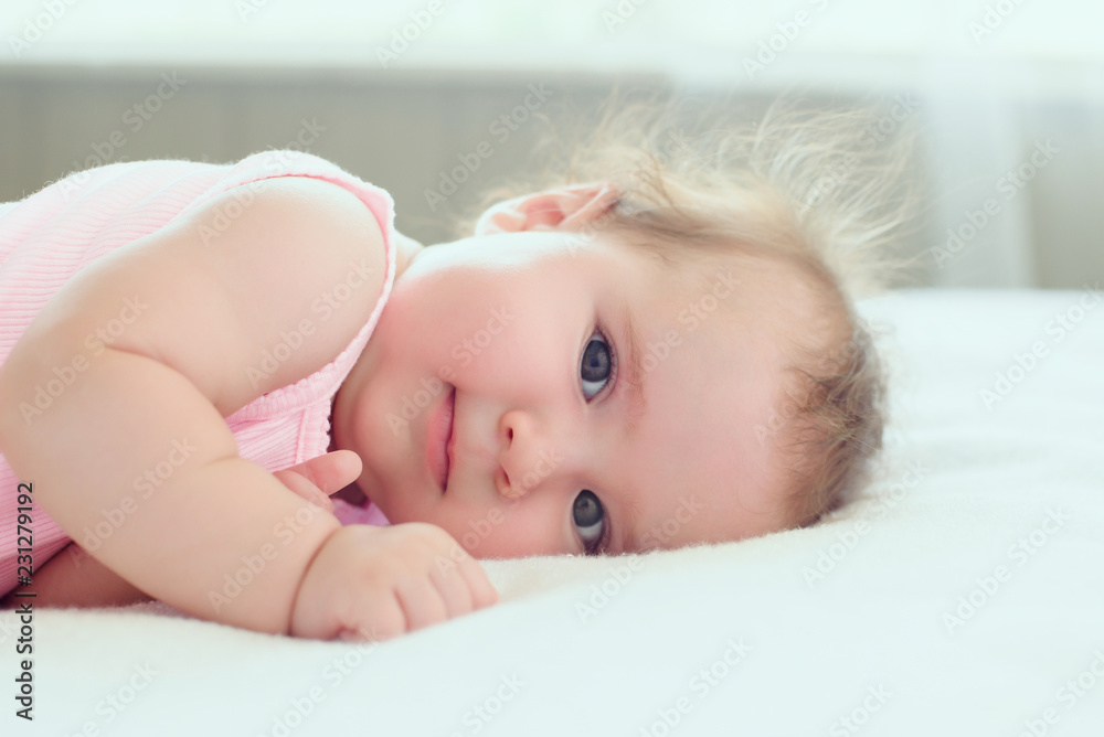 adorable dreamy baby girl 4 months old resting on the bed adorable dreamy baby girl 4 months old resting on the bed
