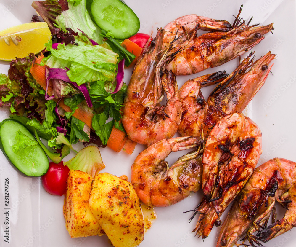 Shrimp Royal cooked fried on a white plate with a side dish of vegetables