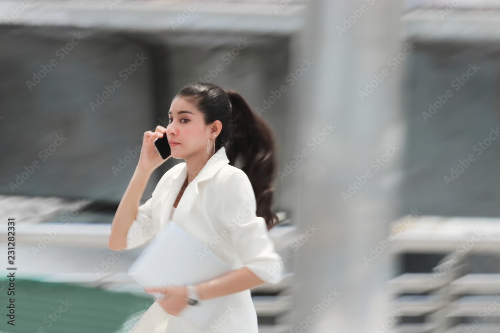 Fototapeta premium Abstract blurred motion of young Asian business woman running to work.