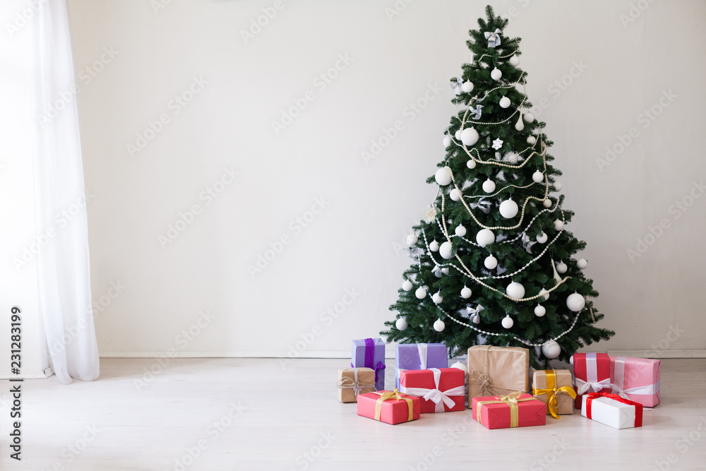 Christmas tree with Christmas gifts in white room