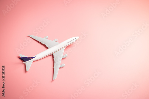 Model plane, top view of airplane on pink color background. travel planning concept