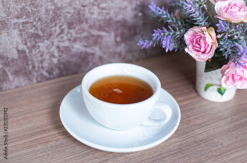 A cup of Chinese tea on wooden table. Beverage for healthy with rose flower in pot