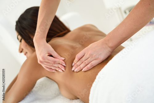 Arab woman receiving back massage in spa wellness center.