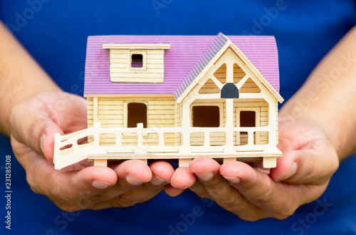 Man holding house model in his hand. The concept of constructing a House, buying, selling.