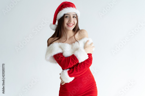 Portrait of happy young woman wearing New Year outfit. Mixed race girl standing hugging self. Christmas or New Year wish concept