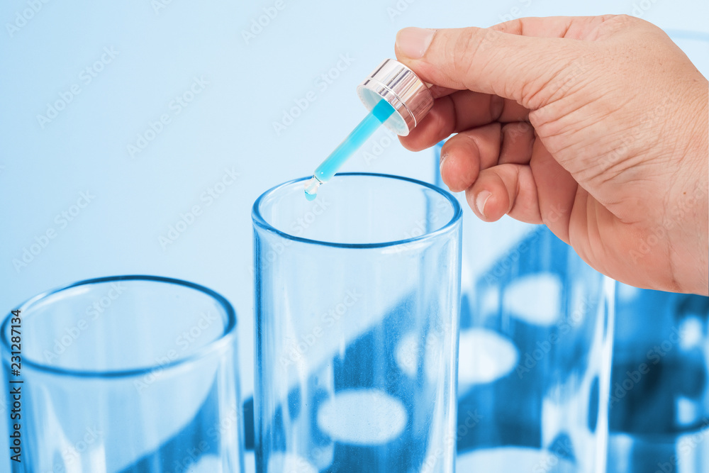 close up hand dropper on test tube on color background. close up hand dropper on test tube on color background.