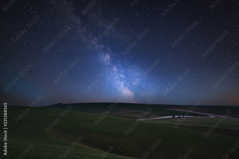 Vibrant Milky Way composite image over landscape of rolling English countryside