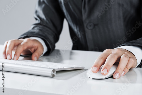 Closeup of businesswoman hand typing on keyboard with mouse on w © adam121