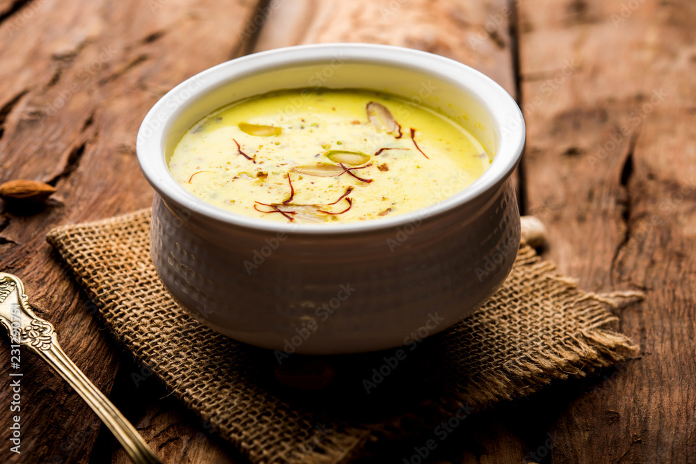 Basundi Or Rabri is an Indian sweet popular in Gujarat and Maharashtra. It is a sweetened condensed milk. Garnished with Dry fruits and Saffron. Served in a bowl over moody background. Selective focus Basundi Or Rabri is an Indian sweet popular in Gujarat and Maharashtra. It is a sweetened condensed milk. Garnished with Dry fruits and Saffron. Served in a bowl over moody background. Selective focus