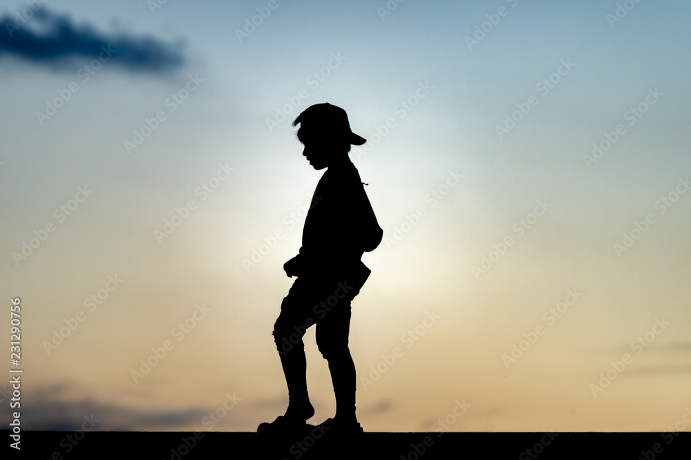 Silhouette of a kid at sunset  - obrazy, fototapety, plakaty 