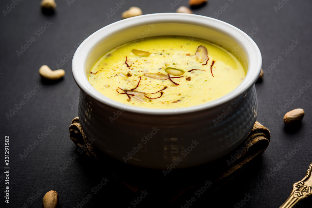 Basundi Or Rabri is an Indian sweet popular in Gujarat and Maharashtra. It is a sweetened condensed milk. Garnished with Dry fruits and Saffron. Served in a bowl over moody background. Selective focus Basundi Or Rabri is an Indian sweet popular in Gujarat and Maharashtra. It is a sweetened condensed milk. Garnished with Dry fruits and Saffron. Served in a bowl over moody background. Selective focus