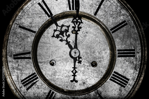 worn clock with roman numerals on a black background, old age concept