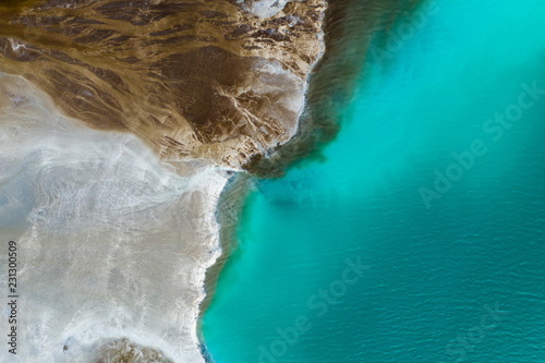 Top down view on rich mineral waste flow from power plant to emerald lake. photo