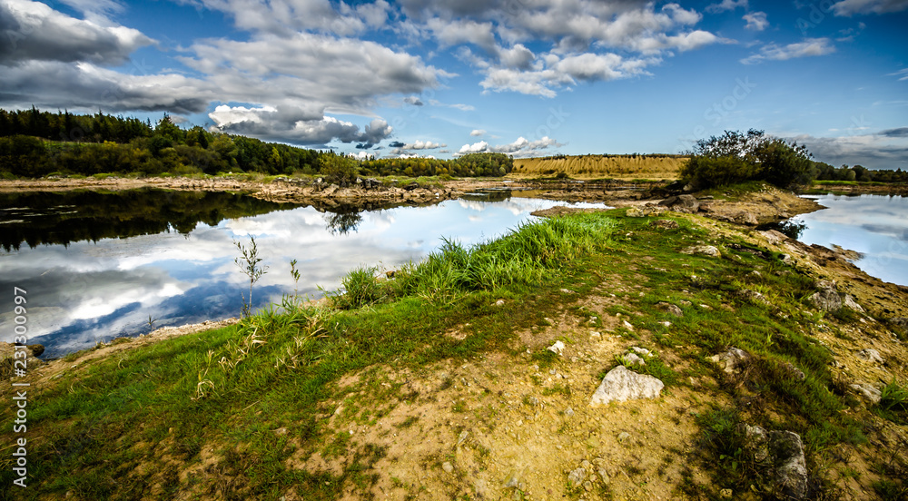 Sandy hills. Lake in the Sandy canyon. Warm colors background. Yellow sandstone textured mountain, white thin sand dune, bright sky. Sunshine landscape