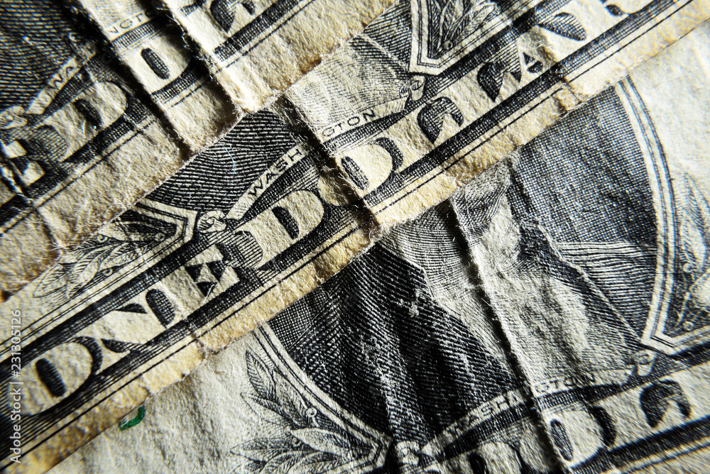 Naklejka premium Dolar USA close-up. Old battered crumpled bills macro. The texture of the fragment of the dollar bill. USD banknote texture.
