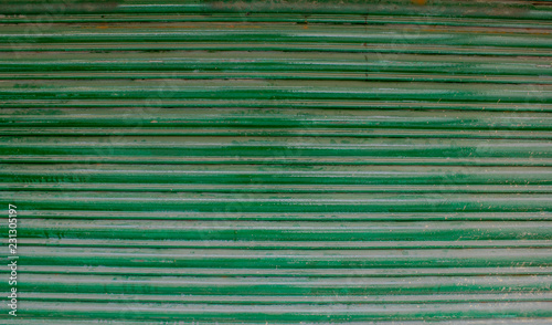 green old horizontal stripes of metallic blinds with rust and paint smudges