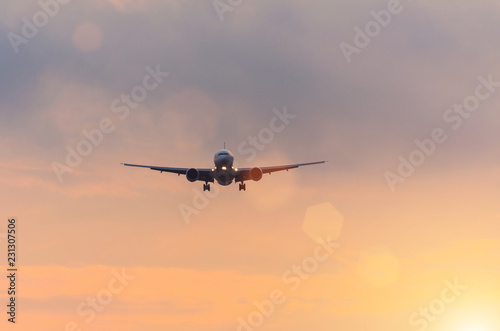 Dark silhouette of an airplane at sunset approach in the airport of a beautiful beautiful sky.