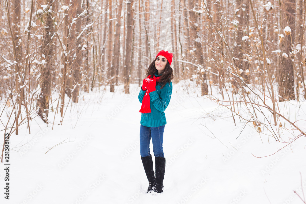 Winter, season and people concept - Young pretty woman walking in snowy park